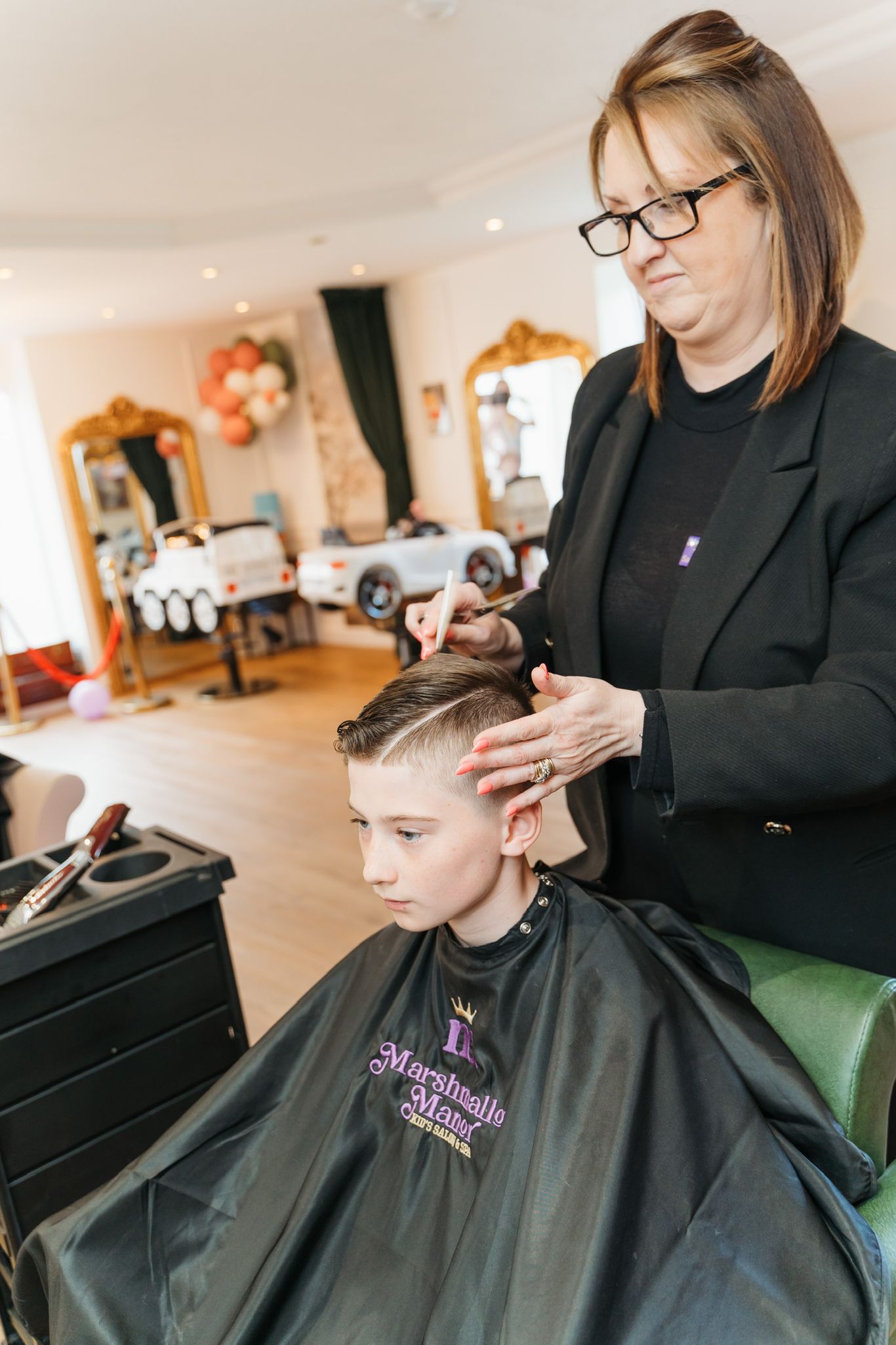 A child having his hair trimmed in the Marshmallow Manor salon