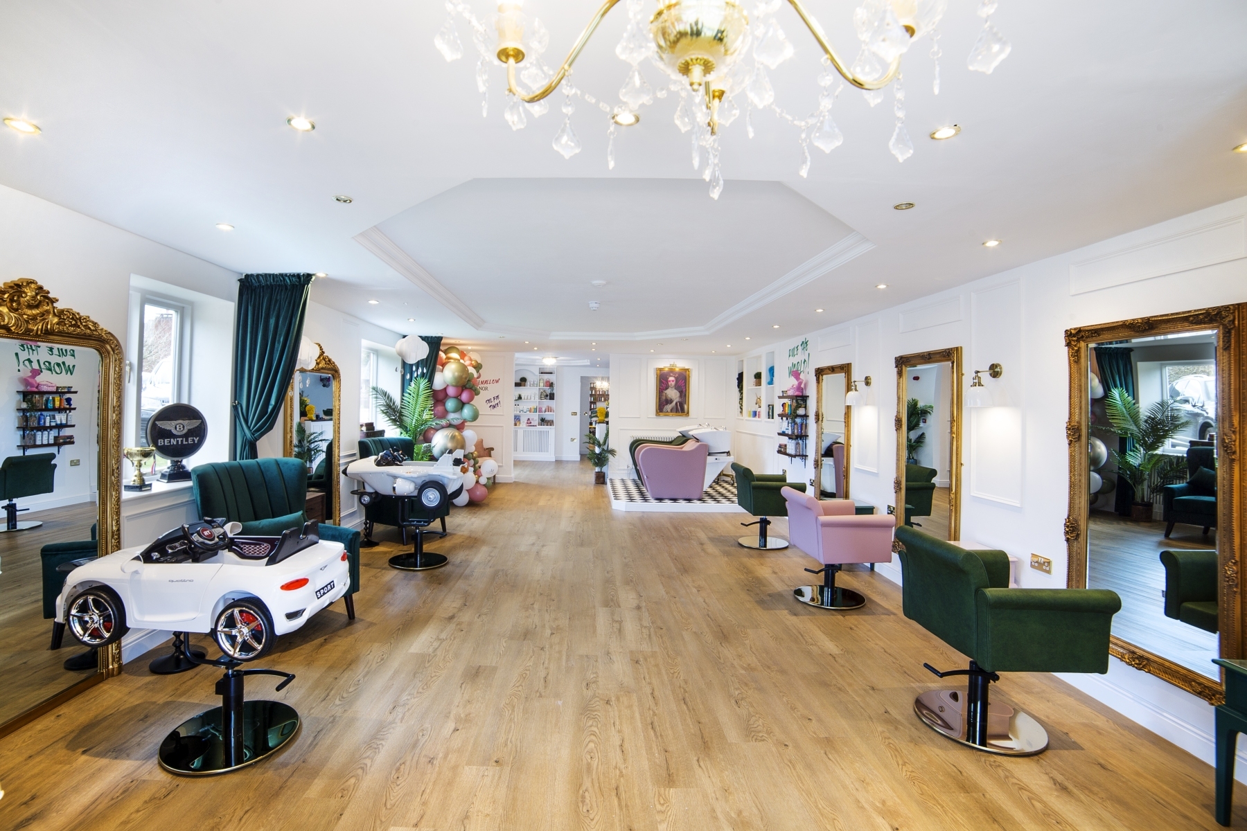 The Marshmallow Manor salon, with car-shaped chairs, gold mirrors and pastel seating